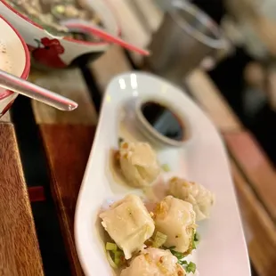 a plate of dumplings and a bowl of soup