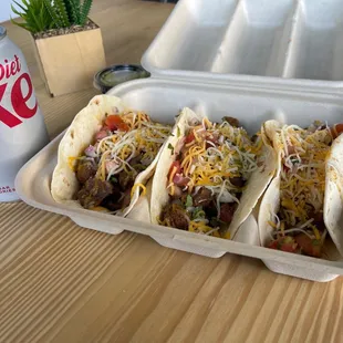 a tray of tacos and a can of coke