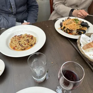 two people sitting at a table with plates of food