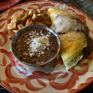 Beef fajita omelette with sautéed veggies, refried beans, and papas fritas