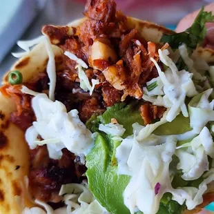 a hand holding a taco