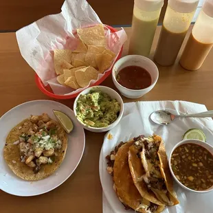 Tres Quesabirria tacos, un consume, un taco de camarones, chips, guacamole y salsa