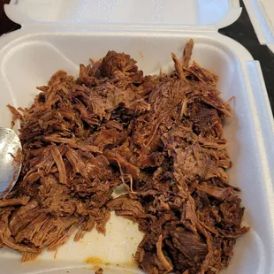 shredded meat in a styrofoam container