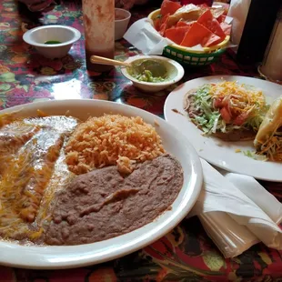 Combination plate of beef enchilada, cheese enchilada, refried beans, Mexican rice, beef puffy taco and one more....