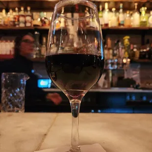 a glass of wine on a bar
