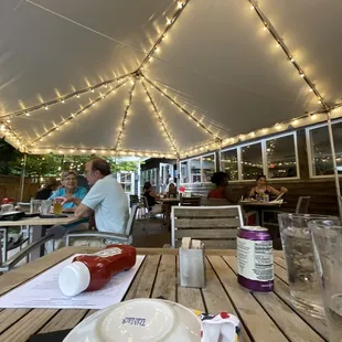 people sitting at tables under a tent