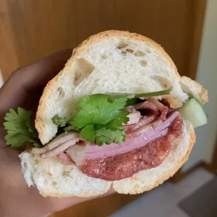 a person holding a sandwich