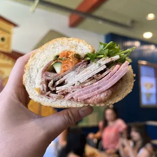 a person holding a sandwich