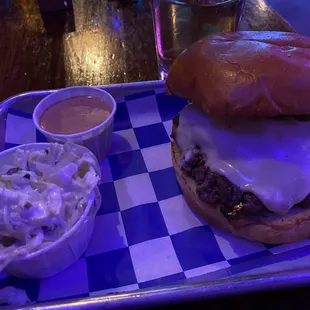 a hamburger and coleslaw on a tray
