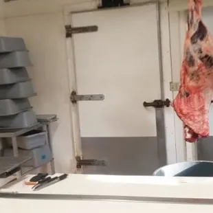 a butcher's kitchen with meat hanging from the ceiling