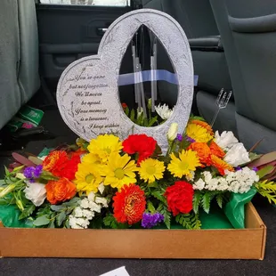 Beautiful flowers and memorial garden stone that has a wind chime