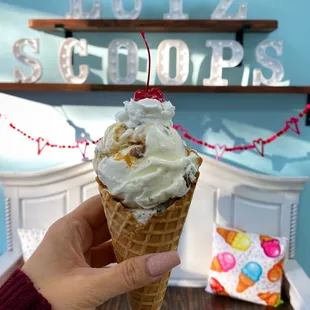 Double scoop in a waffle cone Cookies n cream and snickers with whipped cream and a cherry on top