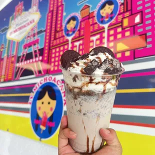 a hand holding a cup of milkshake