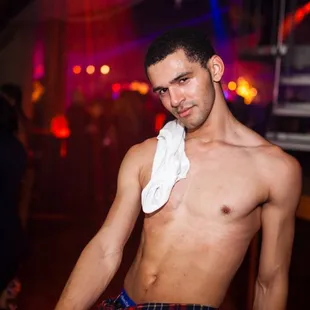 a shirtless man with a towel around his neck
