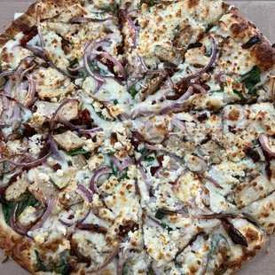 Alfredo chicken pizza; Alfredo sauce, cheese, onions , chicken, sun dried tomatoes and feta