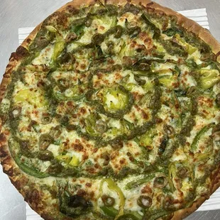 Rocky pizza. Pesto base.mozzarella cheese, spinach, green pepper, green olives, banana peppers