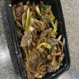 beef and onions in a black container