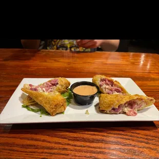 a plate of pastries with dipping sauce
