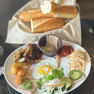 Combos Plate: sunny side egg, shaking beef, Chinese sausage, shredded chicken, pork loaf, tater tots, veggies, aioli, pâté &amp; baguette | $15