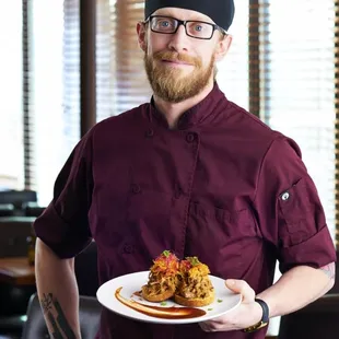 a chef holding a plate of food