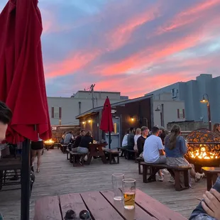 people sitting at tables with umbrellas