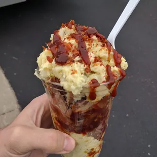 a hand holding a cup of ice cream