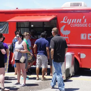 a group of people standing in front of a food truck