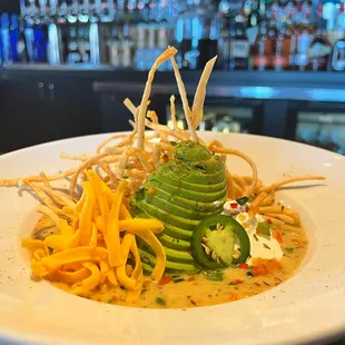 a plate of pasta with avocado and cheese