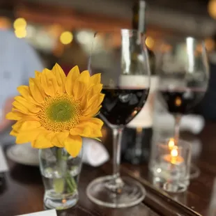 a glass of wine and a sunflower