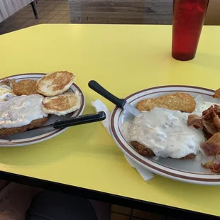 Chicken fried steak, eggs, potato patty, and biscuit.