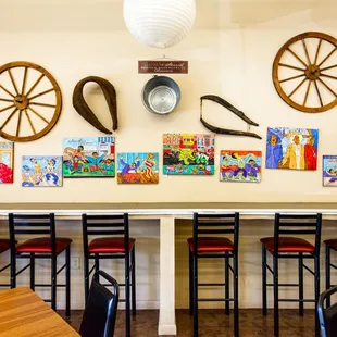 a table with chairs and paintings on the wall