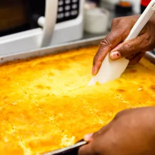 a person using a spatula to make a casserole