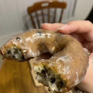 a hand holding a glazed donut