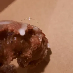 Black string of hair baked into the donut.