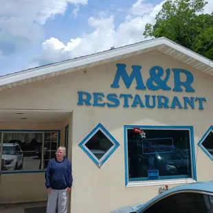 a man standing in front of a restaurant