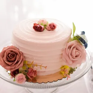 Plain textured white cake with fresh strawberries filling. The flowers were added by my sisters.