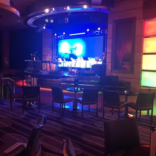 a stage with a large screen in the middle of the room