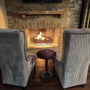 two chairs in front of a fireplace