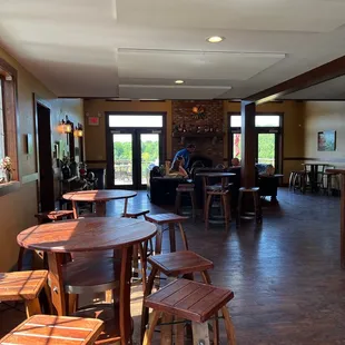 a large room with wooden tables and stools