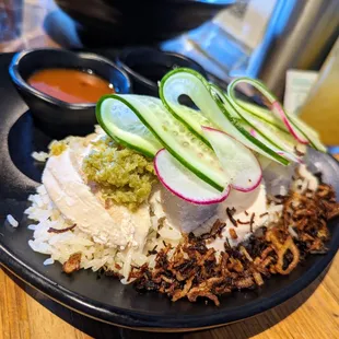 Hainan Chicken. $17. Poached chicken, cucumber salad, chili, and soy sauce. Singapore&apos;s national dish.