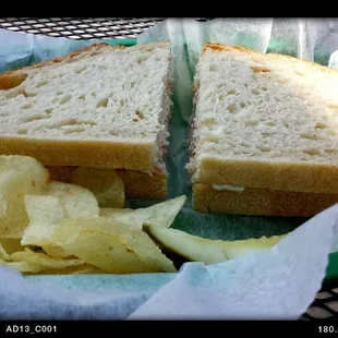 The crab meat sandwich comes with chips and a pickle spear