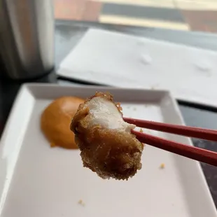 a piece of fried food with chopsticks