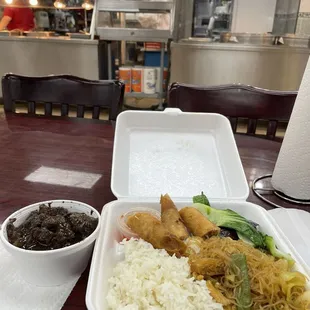  a take out container with rice, meat, and vegetables