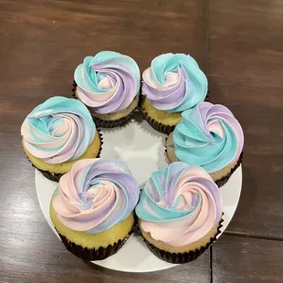 a plate of cupcakes with swirly frosting