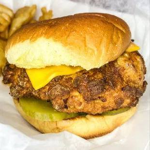 a chicken sandwich with cheese and pickles