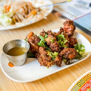 a plate of fried meat and a bowl of sauce