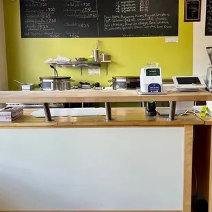 a kitchen counter with a menu on the wall