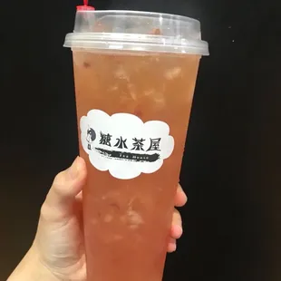 a hand holding a cup of iced tea
