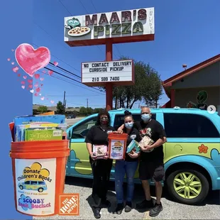 Maar's pizza family with the Scooby Van and the Groovy Book Bucket they use to collect used children's books from the community