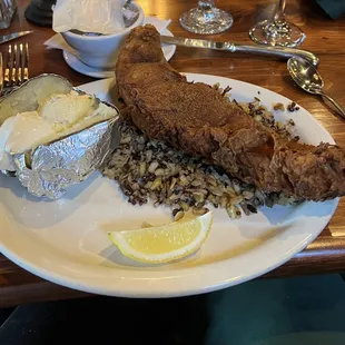 Burnt fish, watch out for bones, with butter loaded with garlic on potato. Not edible!